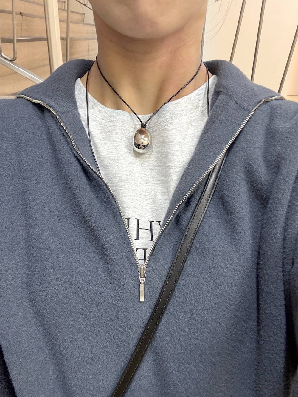 ブラック系のショルダーバッグ、グレー系のニット/セーター、グレー系のTシャツ/カットソーを着用したレディースの秋コーディネートの4枚目の写真