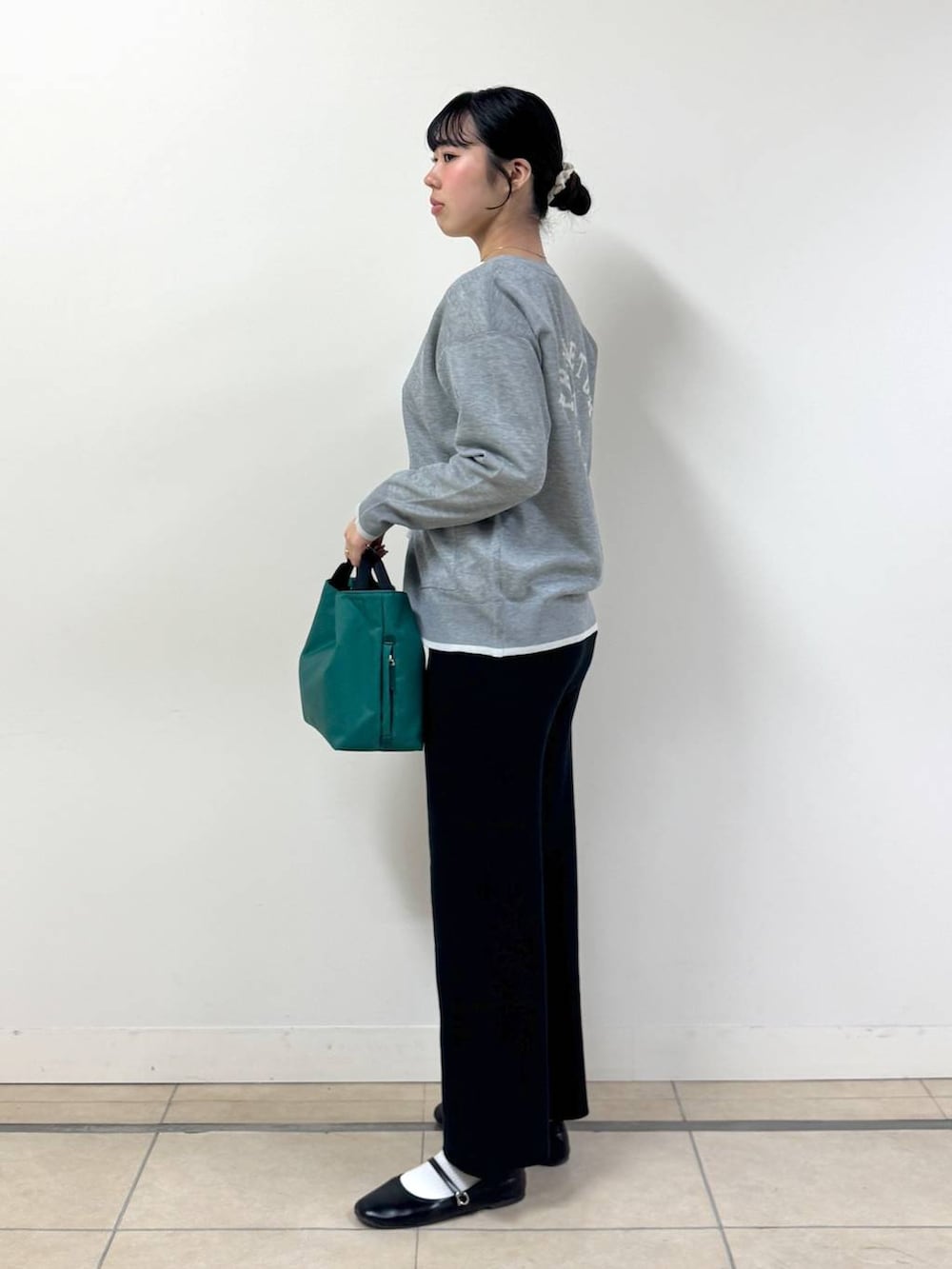 ブラック系のその他パンツ、グリーン系のトートバッグ、ホワイト系のTシャツ/カットソーを着用したレディースの冬コーディネートの2枚目の写真