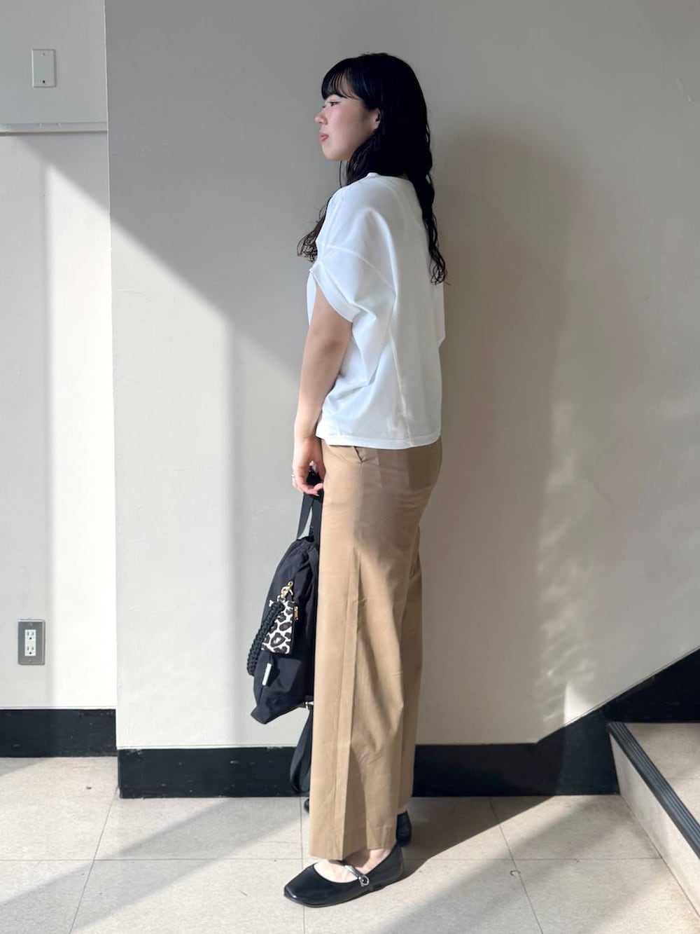 ベージュ系のその他パンツ、ホワイト系のTシャツ/カットソー、ブラック系のバックパック/リュックを着用したレディースの春コーディネートの2枚目の写真