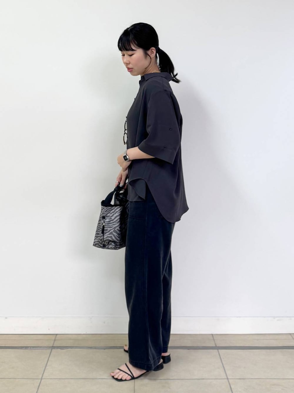 グレー系のトートバッグ、グレー系のシャツ/ブラウス、グレー系のデニムパンツを着用したレディースの春コーディネートの2枚目の写真