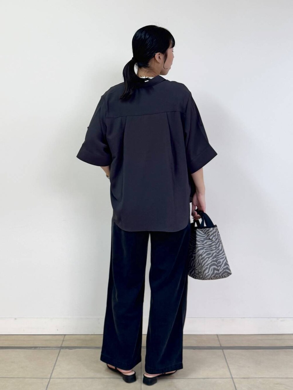 グレー系のトートバッグ、グレー系のシャツ/ブラウス、グレー系のデニムパンツを着用したレディースの春コーディネートの3枚目の写真