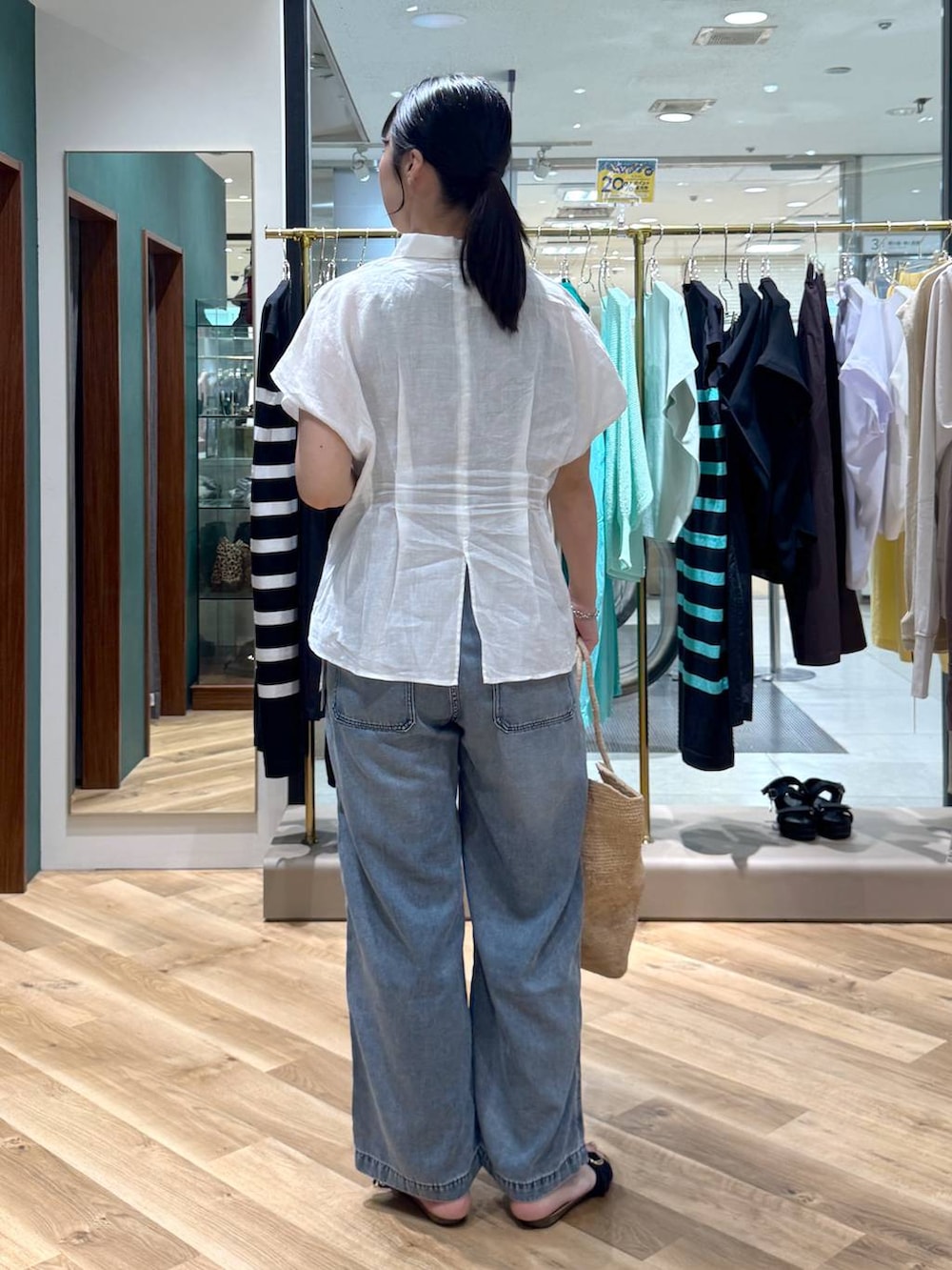 ホワイト系のシャツ/ブラウス、ブラック系のサンダル、ベージュ系のかごバッグを着用したレディースの春コーディネートの3枚目の写真