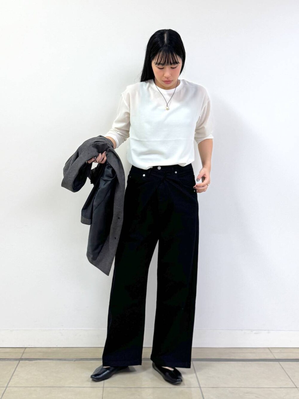 ブラック系のデニムパンツ、ブラウン系のテーラードジャケット、ブラック系のショルダーバッグを着用したレディースの秋コーディネートの4枚目の写真