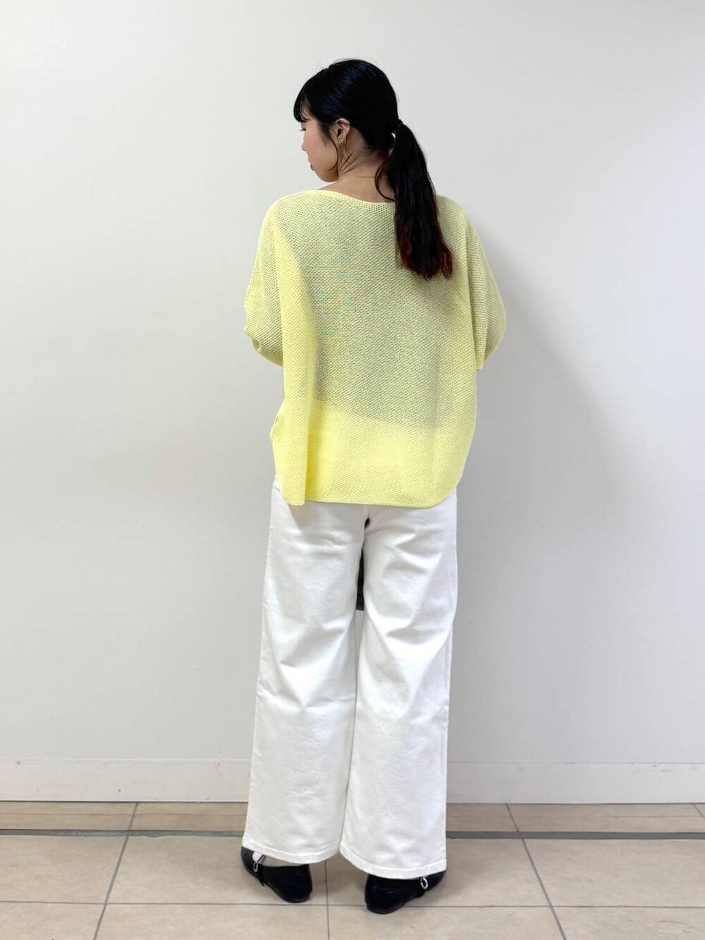 ホワイト系のデニムパンツ、グレー系のTシャツ/カットソー、イエロー系のニット/セーターを着用したレディースの春コーディネートの3枚目の写真