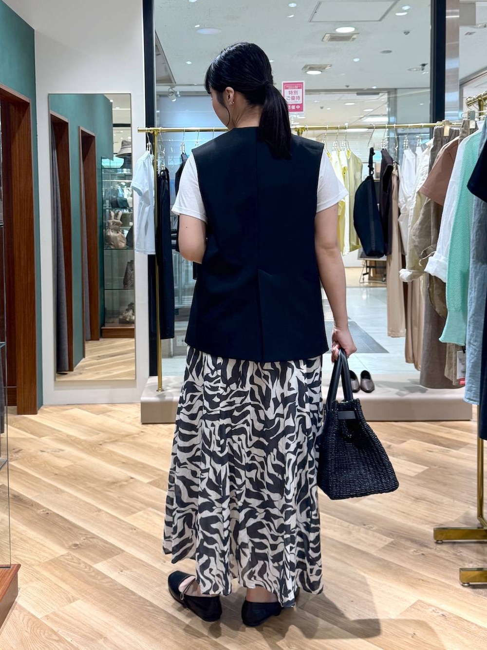 ブラック系のスカート、ブラック系のその他アウター、ホワイト系のTシャツ/カットソーを着用したレディースの春コーディネートの3枚目の写真