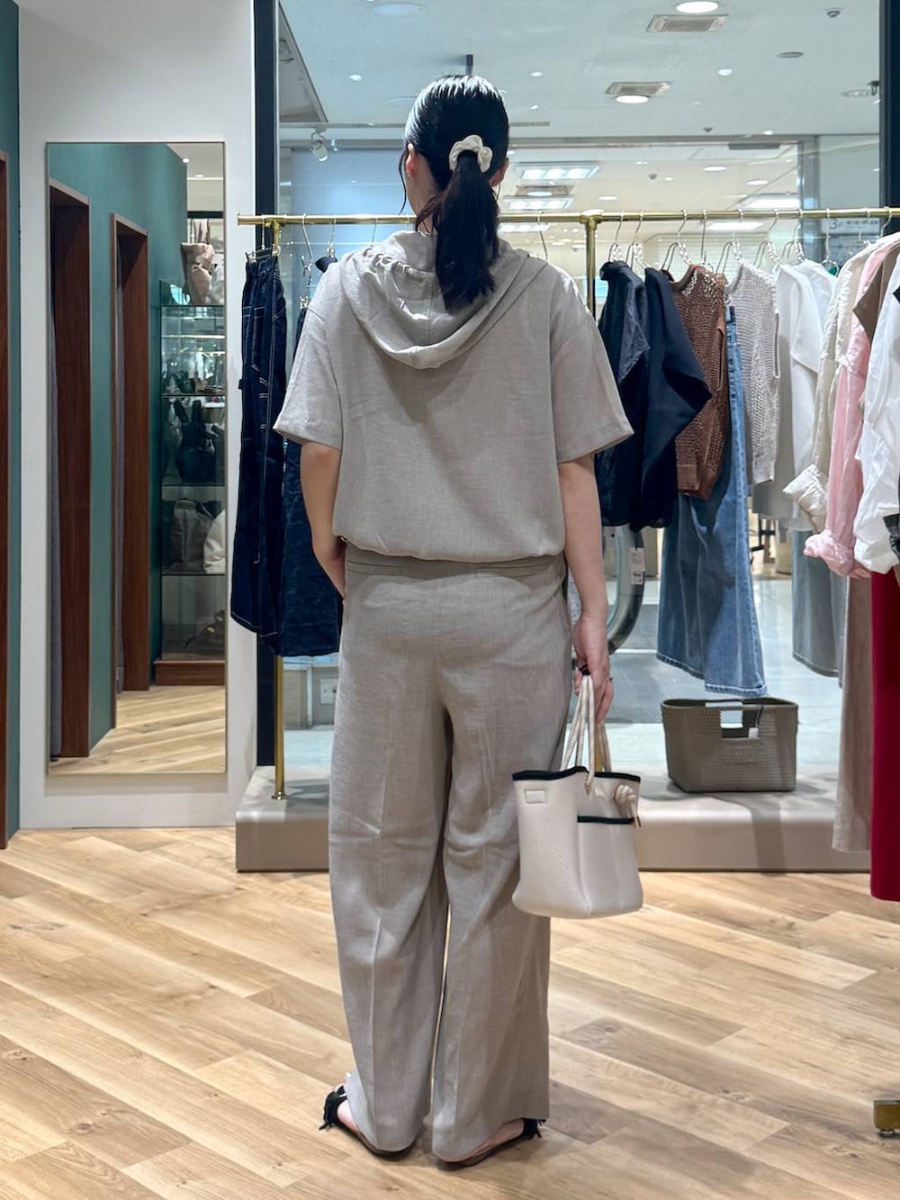 ホワイト系のトートバッグ、ベージュ系のその他パンツ、ベージュ系のブルゾンを着用したレディースの夏コーディネートの3枚目の写真