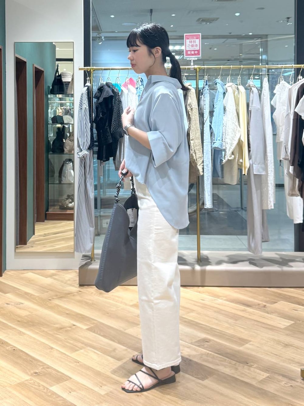 ホワイト系のデニムパンツ、グレー系のトートバッグ、ブルー系のシャツ/ブラウスを着用したレディースの春コーディネートの2枚目の写真