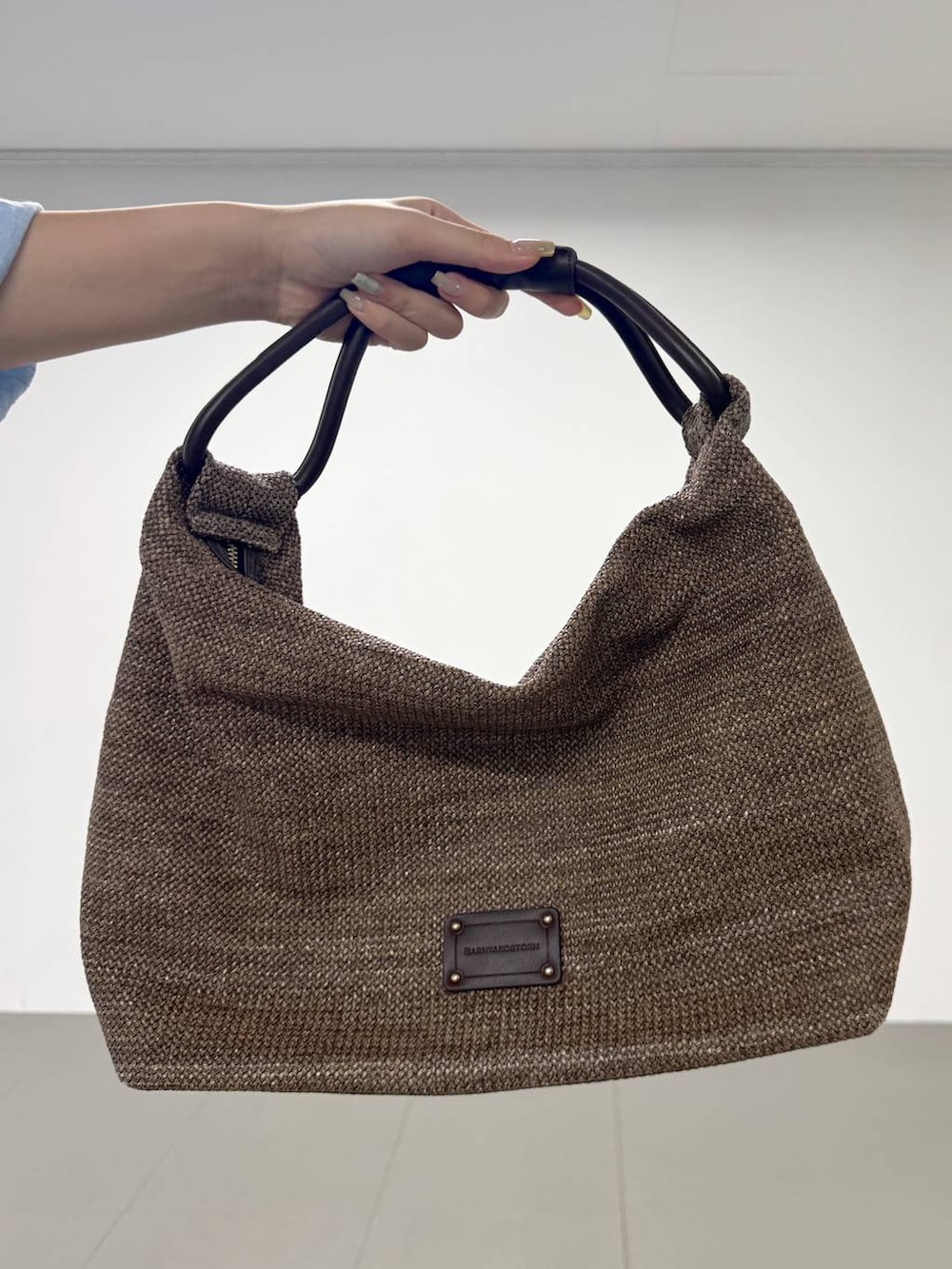 ブラウン系のチノパンツ、グレー系のタンクトップ、ブラウン系のトートバッグを着用したレディースの夏コーディネートの4枚目の写真