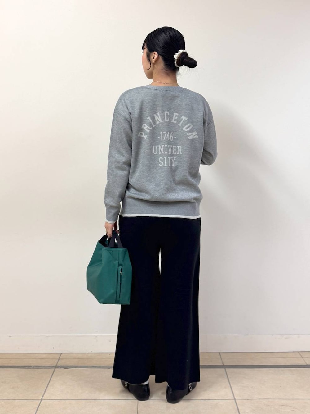 ブラック系のその他パンツ、グリーン系のトートバッグ、ホワイト系のTシャツ/カットソーを着用したレディースの冬コーディネートの3枚目の写真