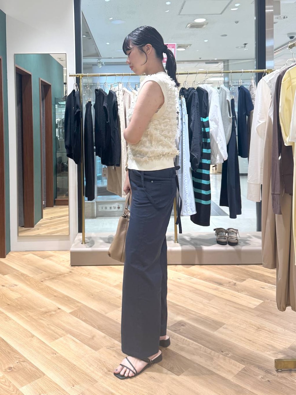イエロー系のトートバッグ、ブルー系のその他パンツ、ホワイト系のニット/セーターを着用したレディースの春コーディネートの2枚目の写真