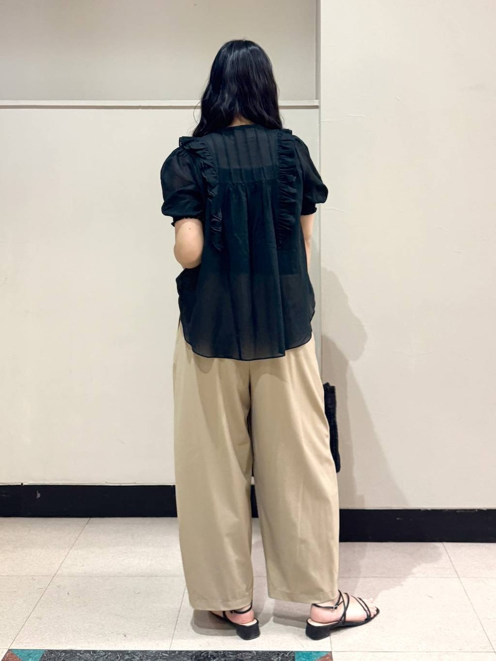 ブラック系のシャツ/ブラウス、ベージュ系のその他パンツ、ブラック系のかごバッグを着用したレディースの春コーディネートの2枚目の写真