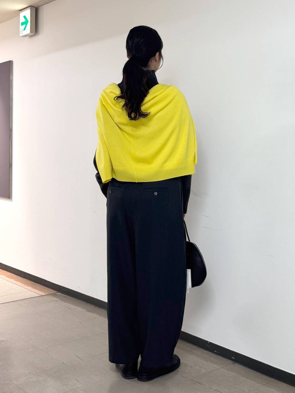 ブラック系のトートバッグ、グレー系のニット/セーター、グレー系のスラックスを着用したレディースの冬コーディネートの3枚目の写真