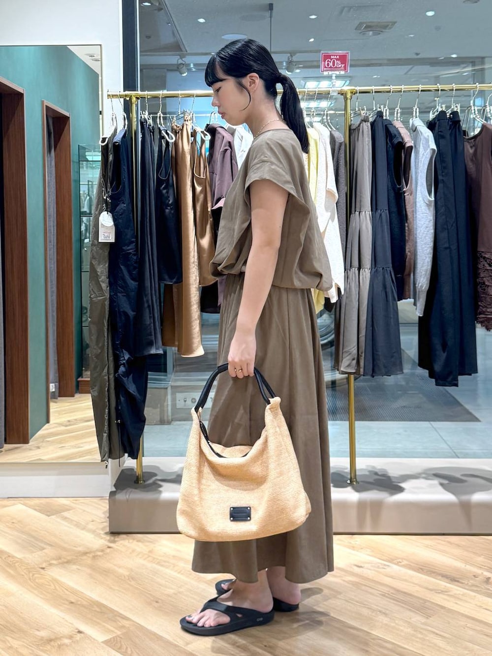 ベージュ系のシャツ/ブラウス、ベージュ系のスカート、ブラック系のトートバッグを着用したレディースの夏コーディネートの2枚目の写真