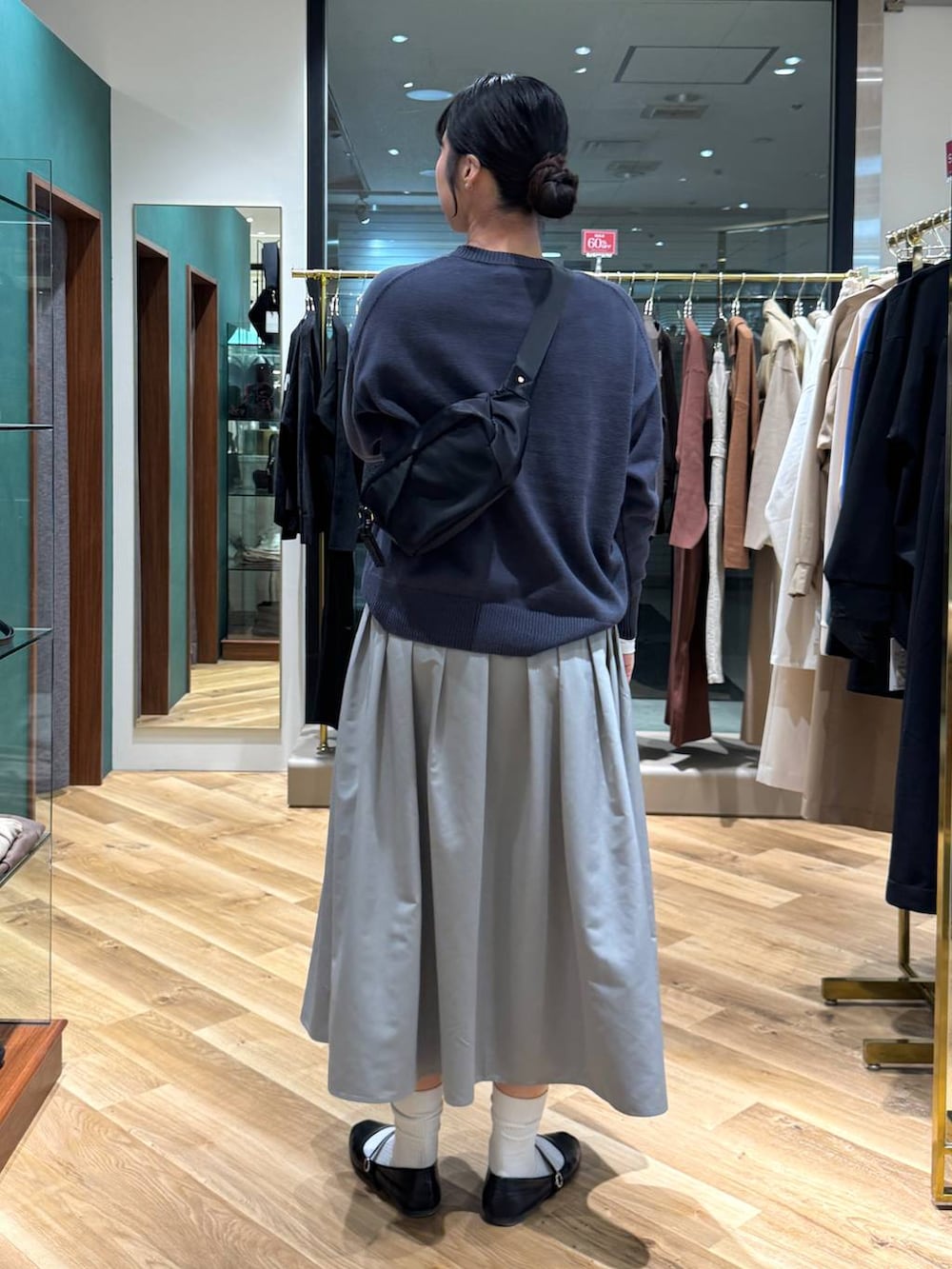 ホワイト系のTシャツ/カットソー、グレー系のニット/セーター、グレー系のスカートを着用したレディースの冬コーディネートの3枚目の写真