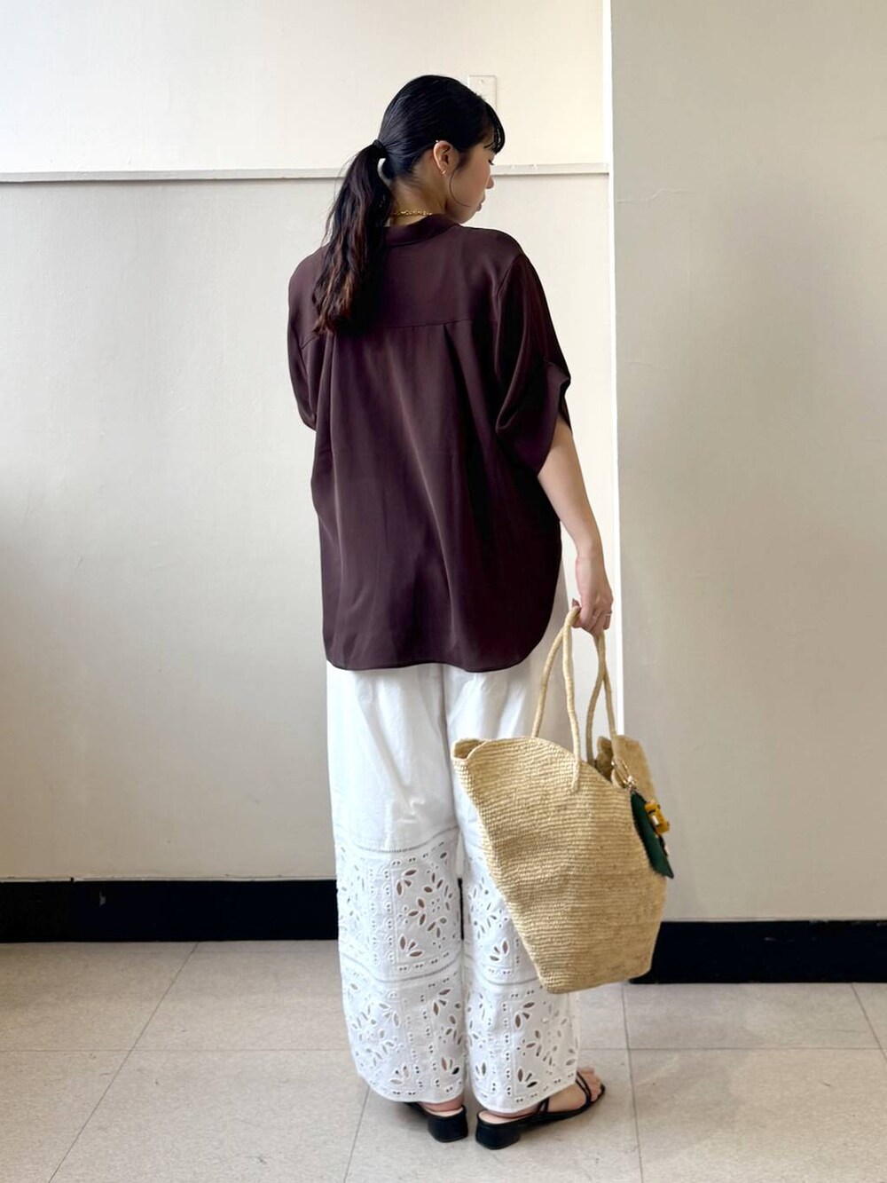 ホワイト系のその他パンツ、ブラウン系のシャツ/ブラウス、ベージュ系のかごバッグを着用したレディースの春コーディネートの3枚目の写真