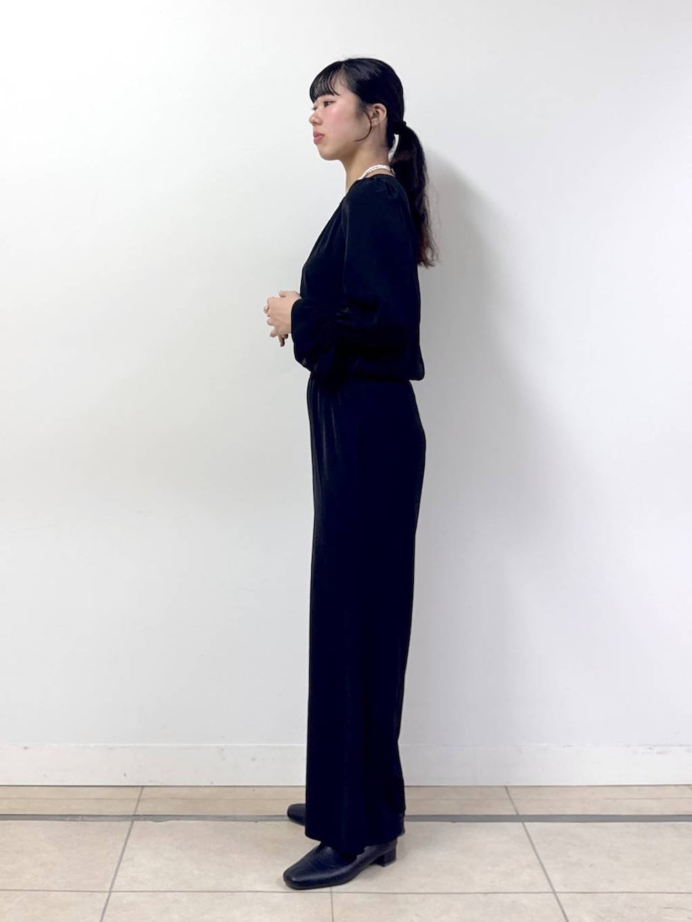 ブラック系のつなぎ/オールインワン、ブラック系のノーカラージャケット、その他のネックレスを着用したレディースの冬コーディネートの5枚目の写真