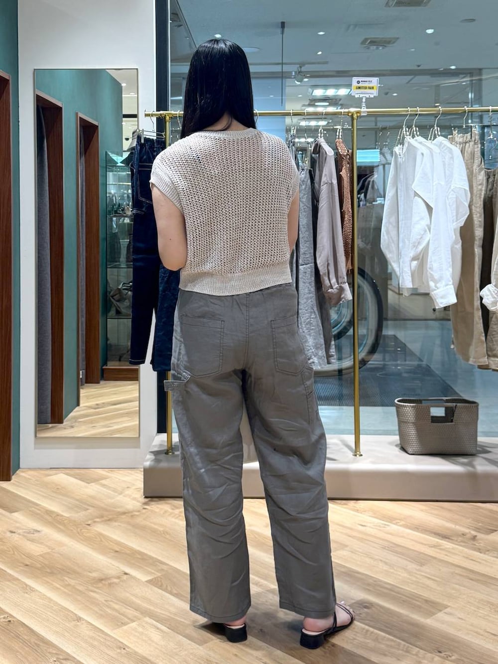 ホワイト系のショルダーバッグ、グレー系のその他パンツ、ベージュ系のニット/セーターを着用したレディースの夏コーディネートの3枚目の写真
