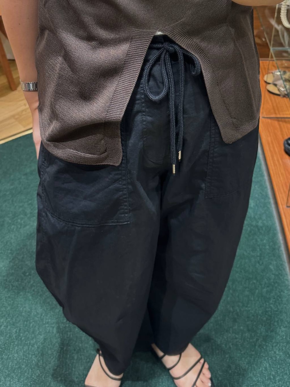 ホワイト系のショルダーバッグ、ブラック系のカーゴパンツ、ブラウン系のニット/セーターを着用したレディースの夏コーディネートの3枚目の写真