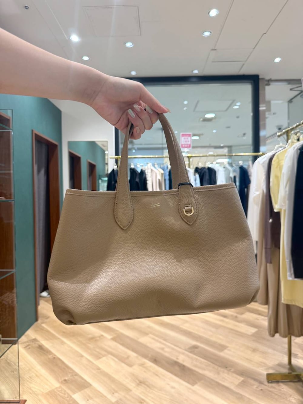 イエロー系のトートバッグ、ブルー系のその他パンツ、ホワイト系のニット/セーターを着用したレディースの春コーディネートの4枚目の写真