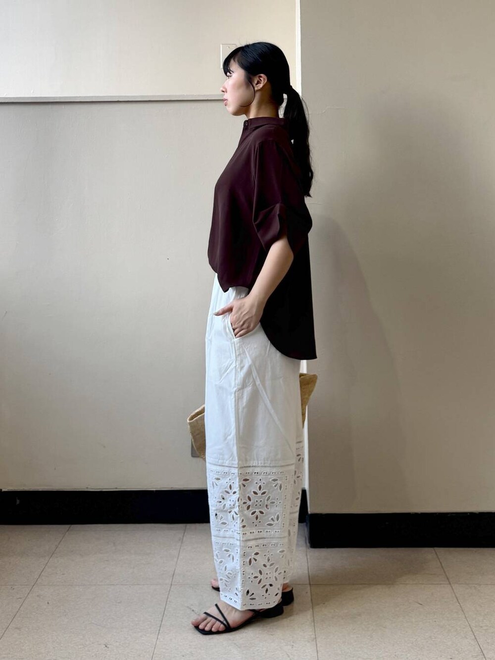 ホワイト系のその他パンツ、ブラウン系のシャツ/ブラウス、ベージュ系のかごバッグを着用したレディースの春コーディネートの2枚目の写真