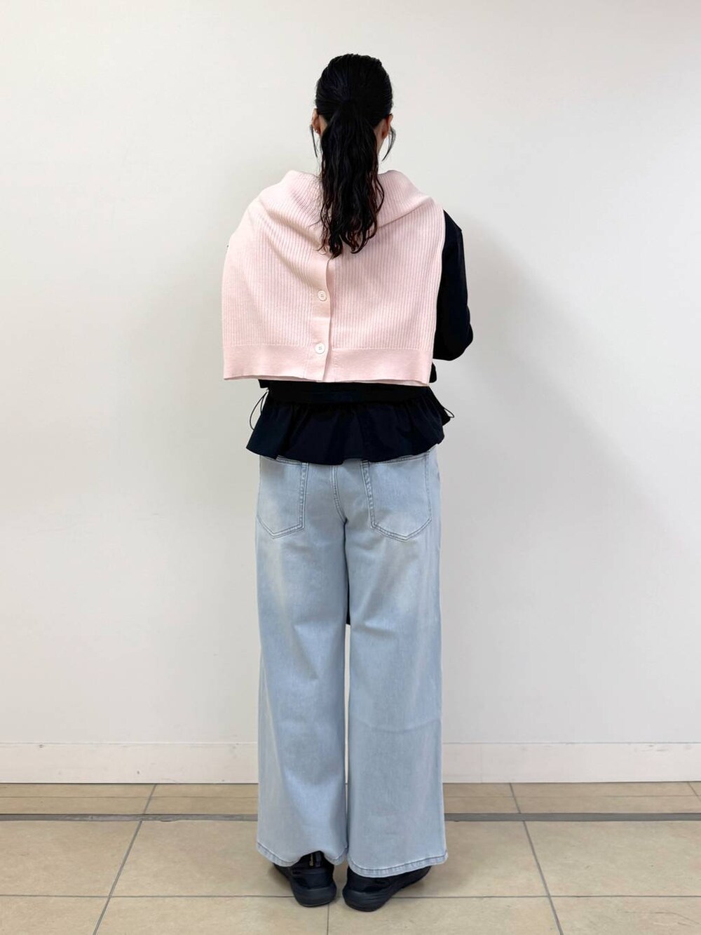 ブルー系のデニムパンツ、ピンク系のカーディガン/ボレロ、ブラック系のTシャツ/カットソーを着用したレディースの冬コーディネートの3枚目の写真
