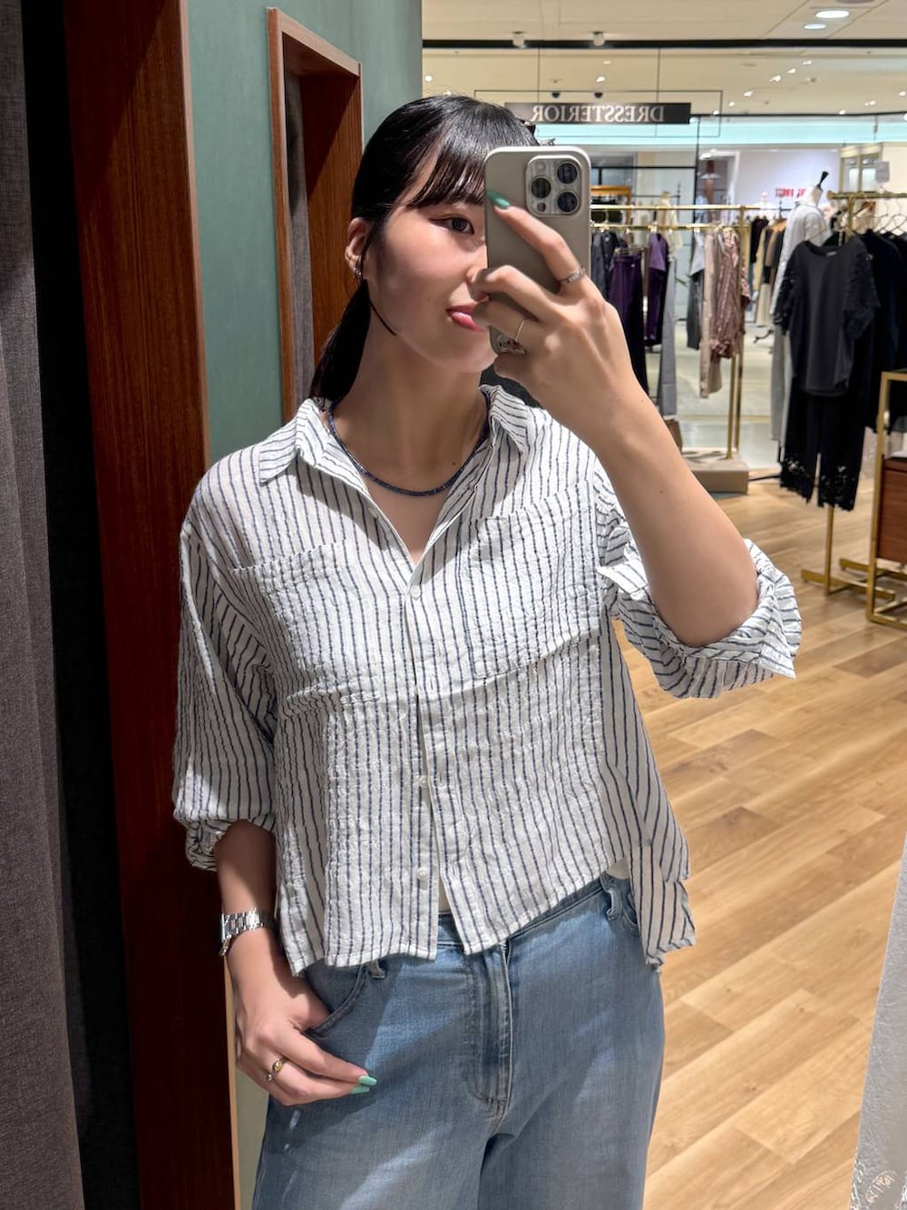 ホワイト系のシャツ/ブラウス、ブルー系のデニムパンツ、ブルー系のネックレスを着用したレディースの夏コーディネートの3枚目の写真