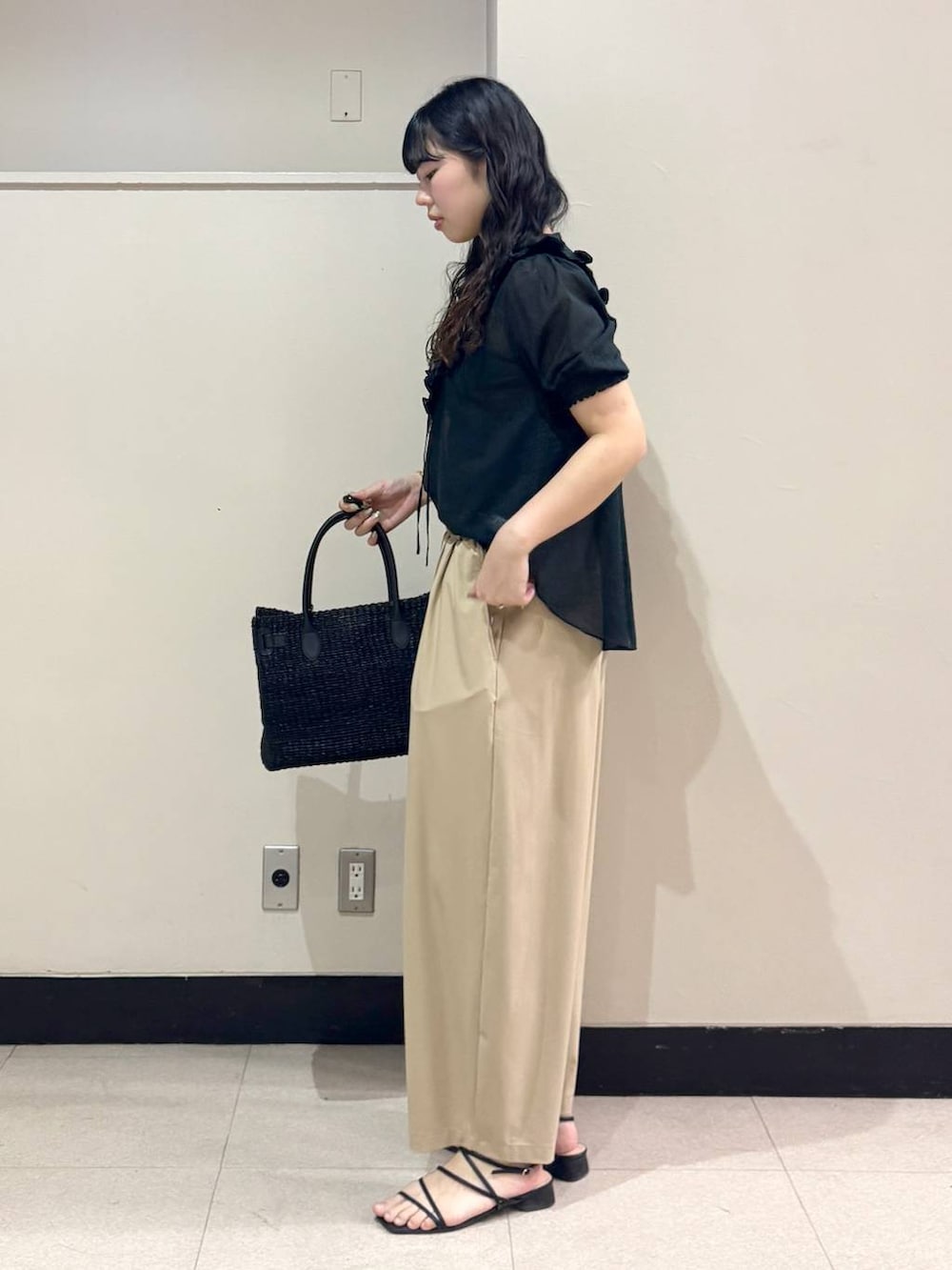 ブラック系のシャツ/ブラウス、ベージュ系のその他パンツ、ブラック系のかごバッグを着用したレディースの春コーディネートの3枚目の写真