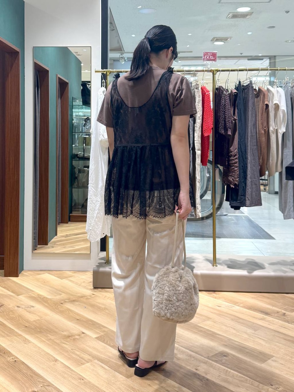 ホワイト系のチノパンツ、ブラウン系のTシャツ/カットソー、ブラック系のシャツ/ブラウスを着用したレディースの夏コーディネートの3枚目の写真