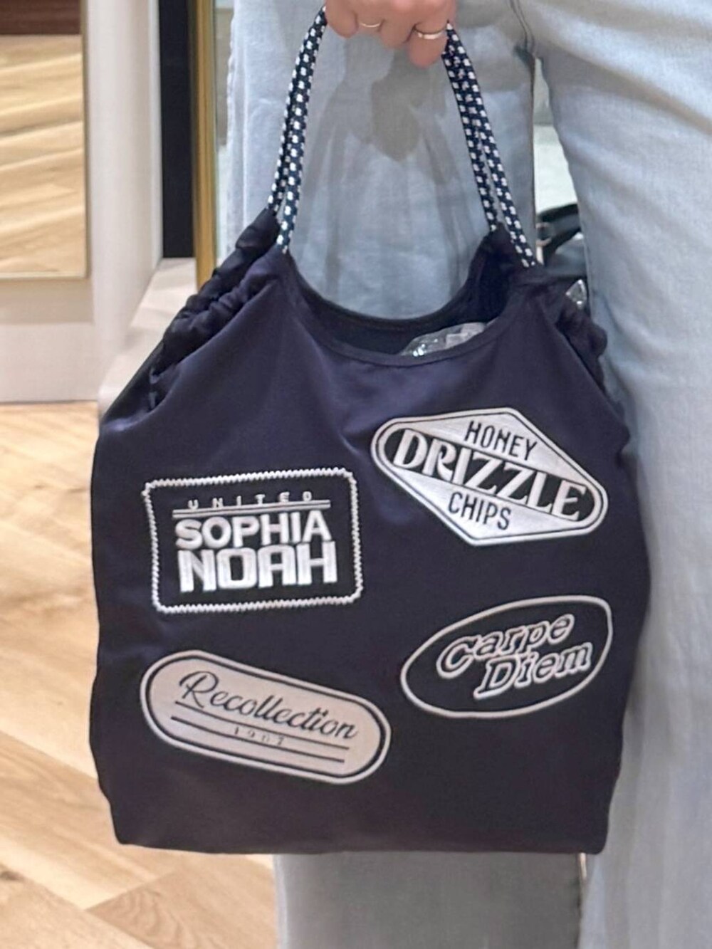 ブルー系のデニムパンツ、ブルー系のトートバッグ、ベージュ系のシャツ/ブラウスを着用したレディースの夏コーディネートの4枚目の写真