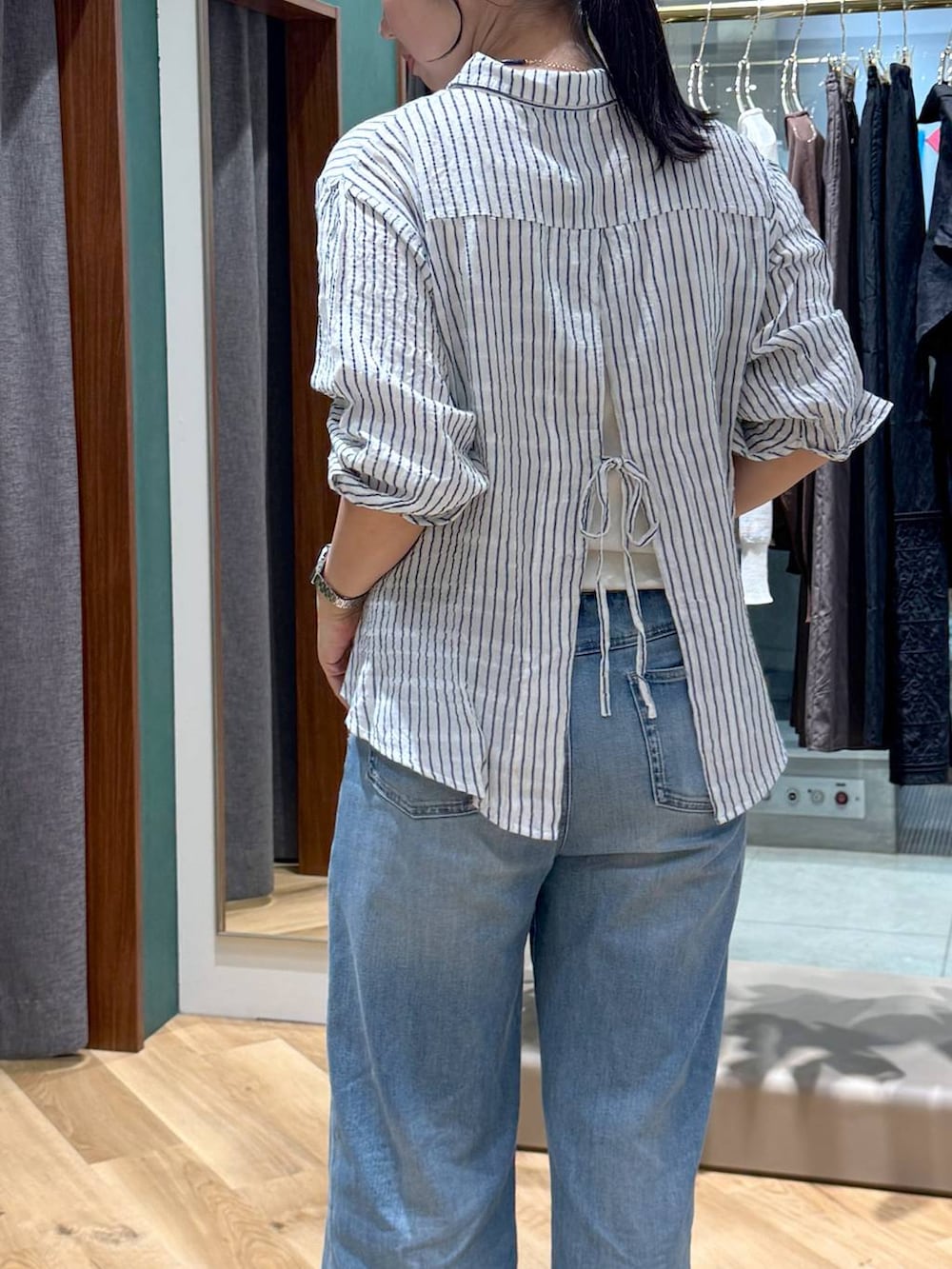 ホワイト系のシャツ/ブラウス、ブルー系のデニムパンツ、ブルー系のネックレスを着用したレディースの夏コーディネートの2枚目の写真