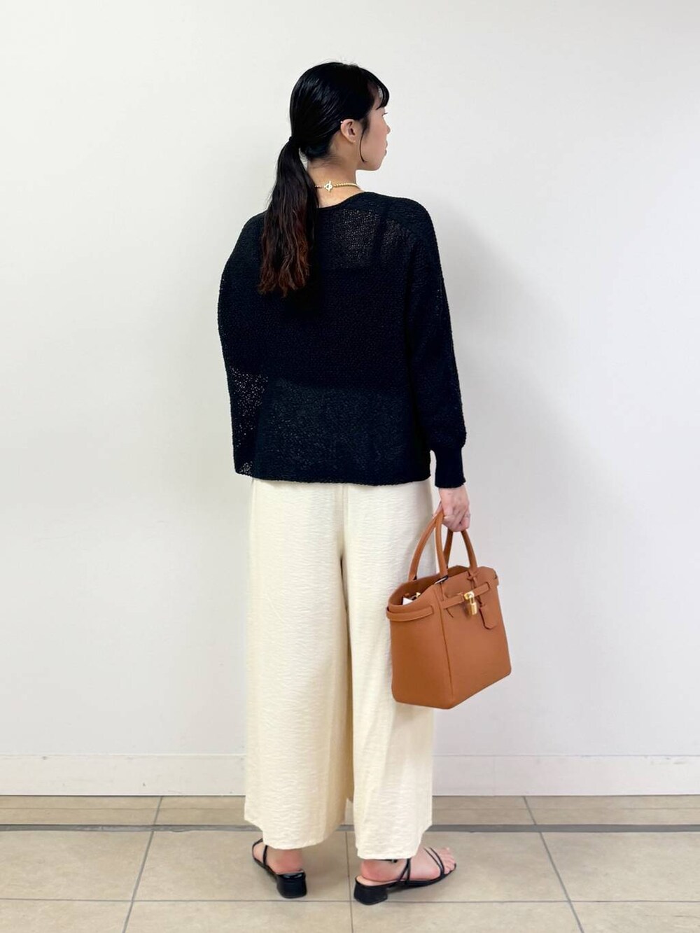 ブラック系のキャミソール、ブラック系のカーディガン/ボレロ、ホワイト系のその他パンツを着用したレディースの春コーディネートの3枚目の写真