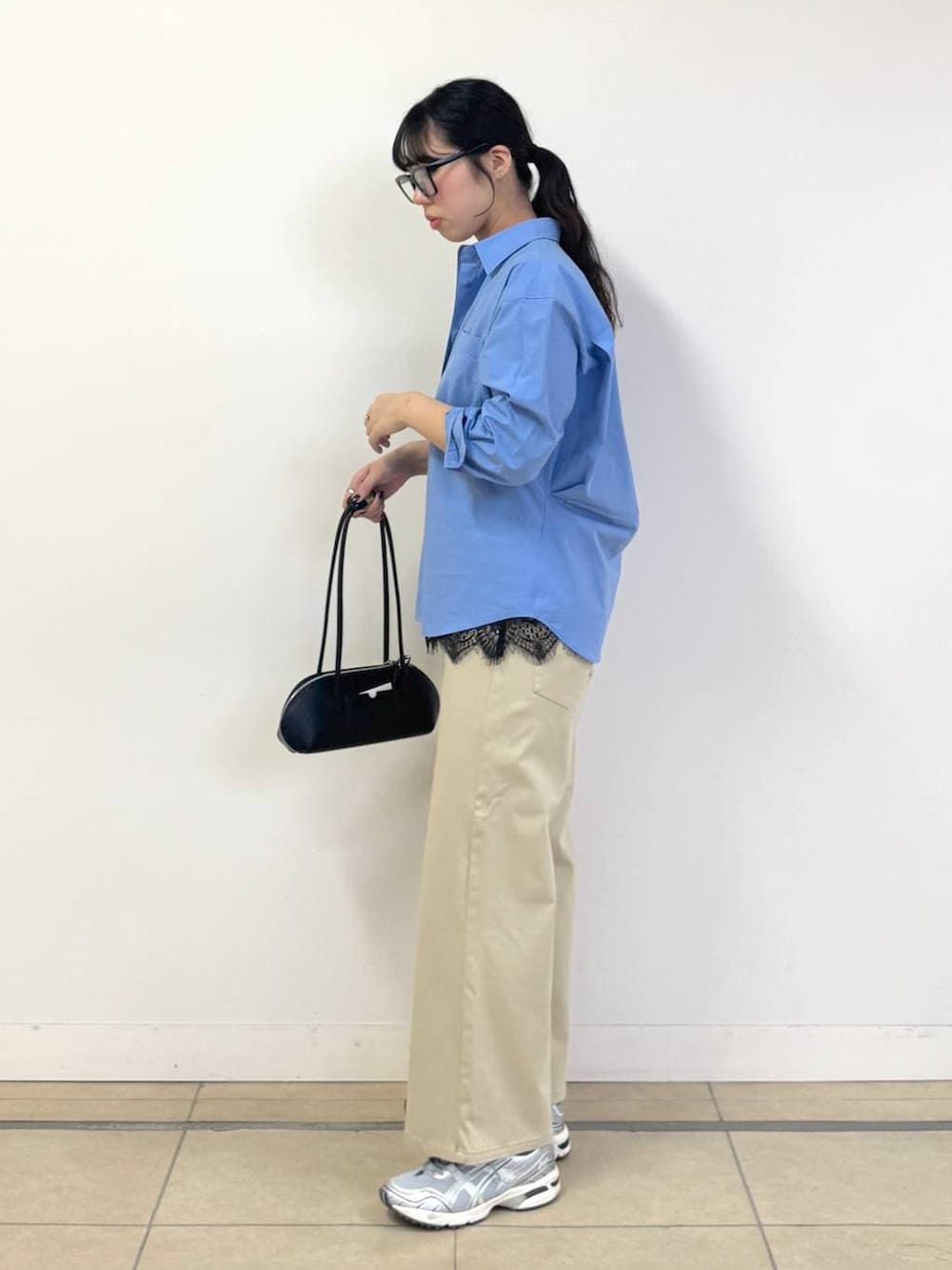 ベージュ系のデニムパンツ、ブルー系のシャツ/ブラウス、ブラック系のハンドバッグを着用したレディースの冬コーディネートの2枚目の写真