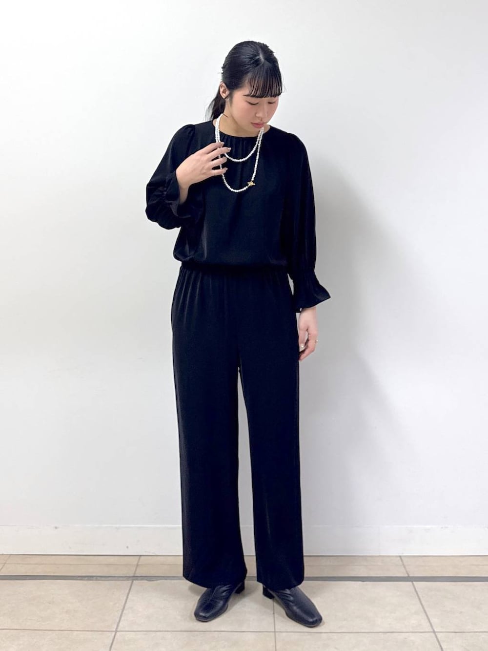 ブラック系のつなぎ/オールインワン、ブラック系のノーカラージャケット、その他のネックレスを着用したレディースの冬コーディネートの4枚目の写真