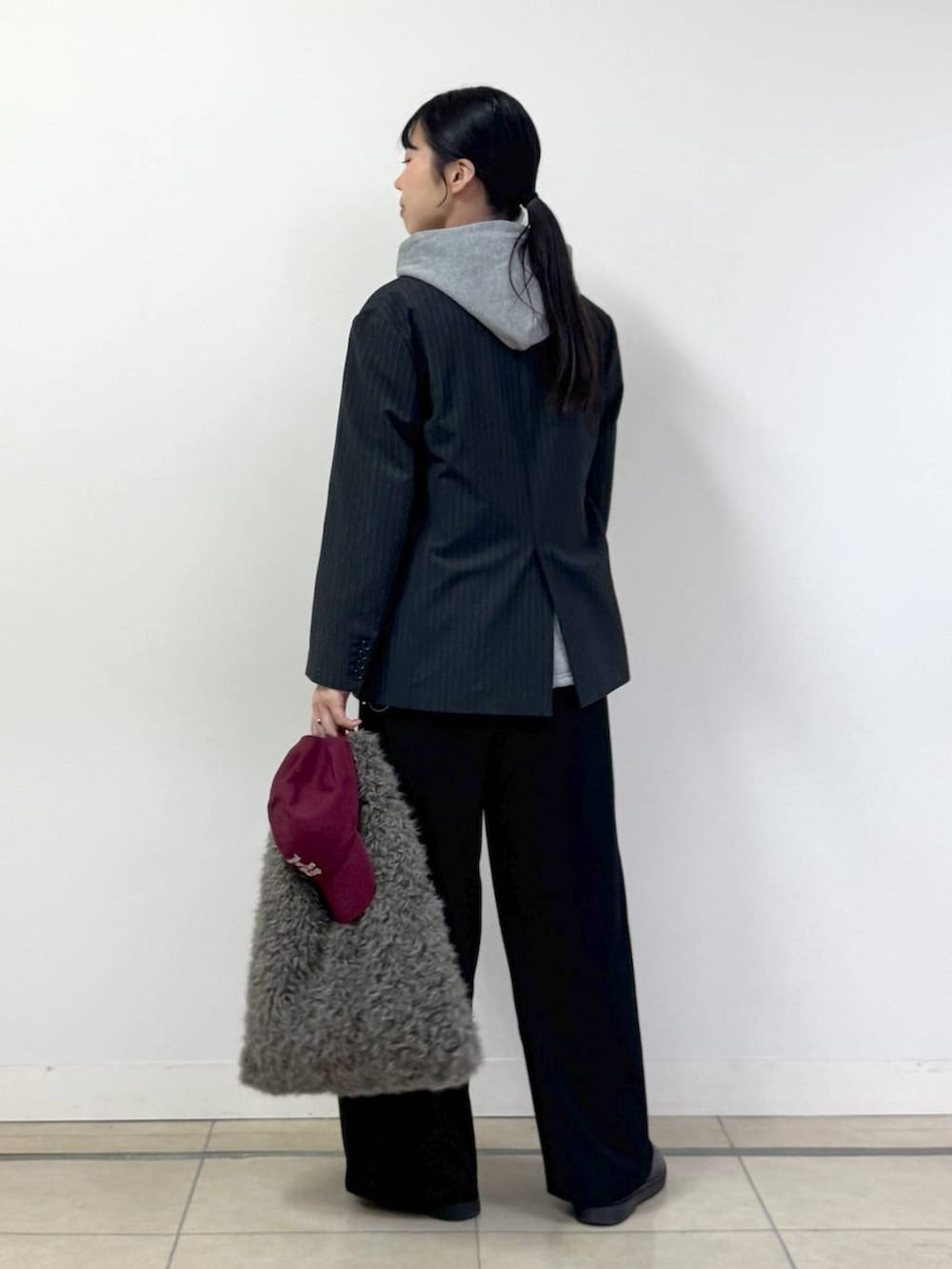 グレー系のテーラードジャケット、グレー系のパーカー、ブラック系のその他パンツを着用したレディースの秋コーディネートの3枚目の写真