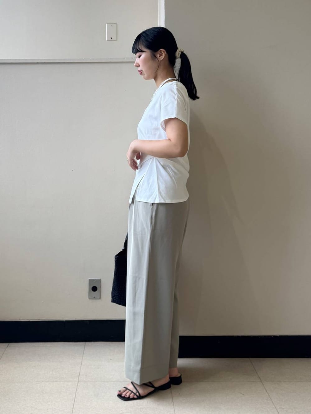 ブラック系のトートバッグ、ホワイト系のTシャツ/カットソー、ベージュ系のその他パンツを着用したレディースの夏コーディネートの2枚目の写真
