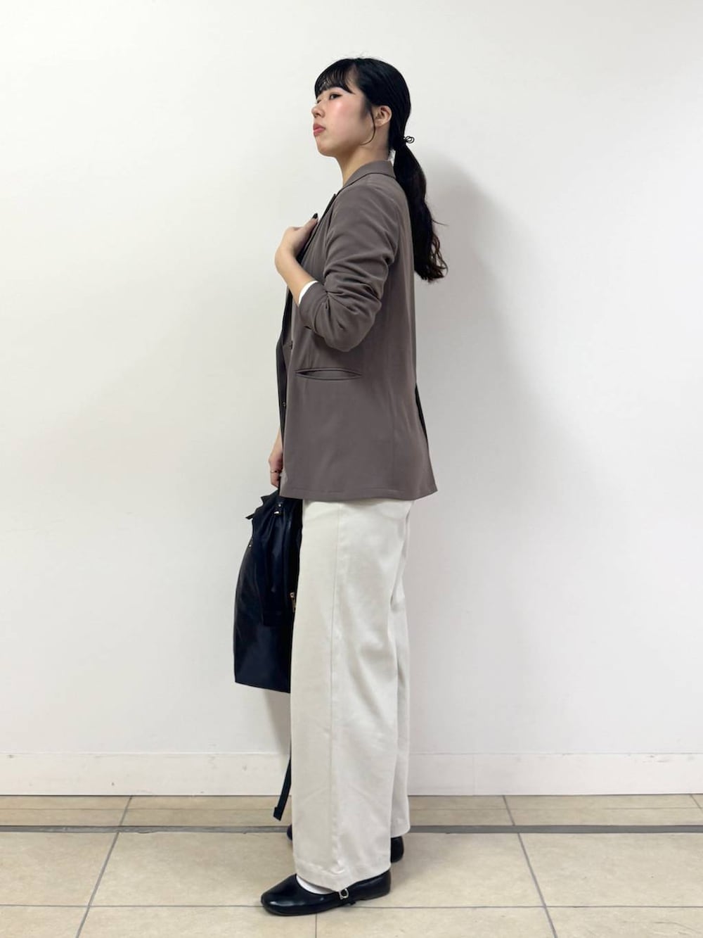 ブラック系のバックパック/リュック、ホワイト系のTシャツ/カットソー、ベージュ系のその他パンツを着用したレディースの冬コーディネートの2枚目の写真