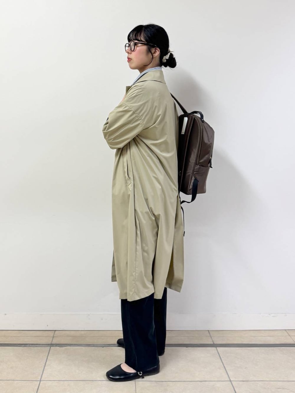 ブラック系のその他パンツ、ブルー系のシャツ/ブラウス、ベージュ系のステンカラーコートを着用したレディースの春コーディネートの2枚目の写真