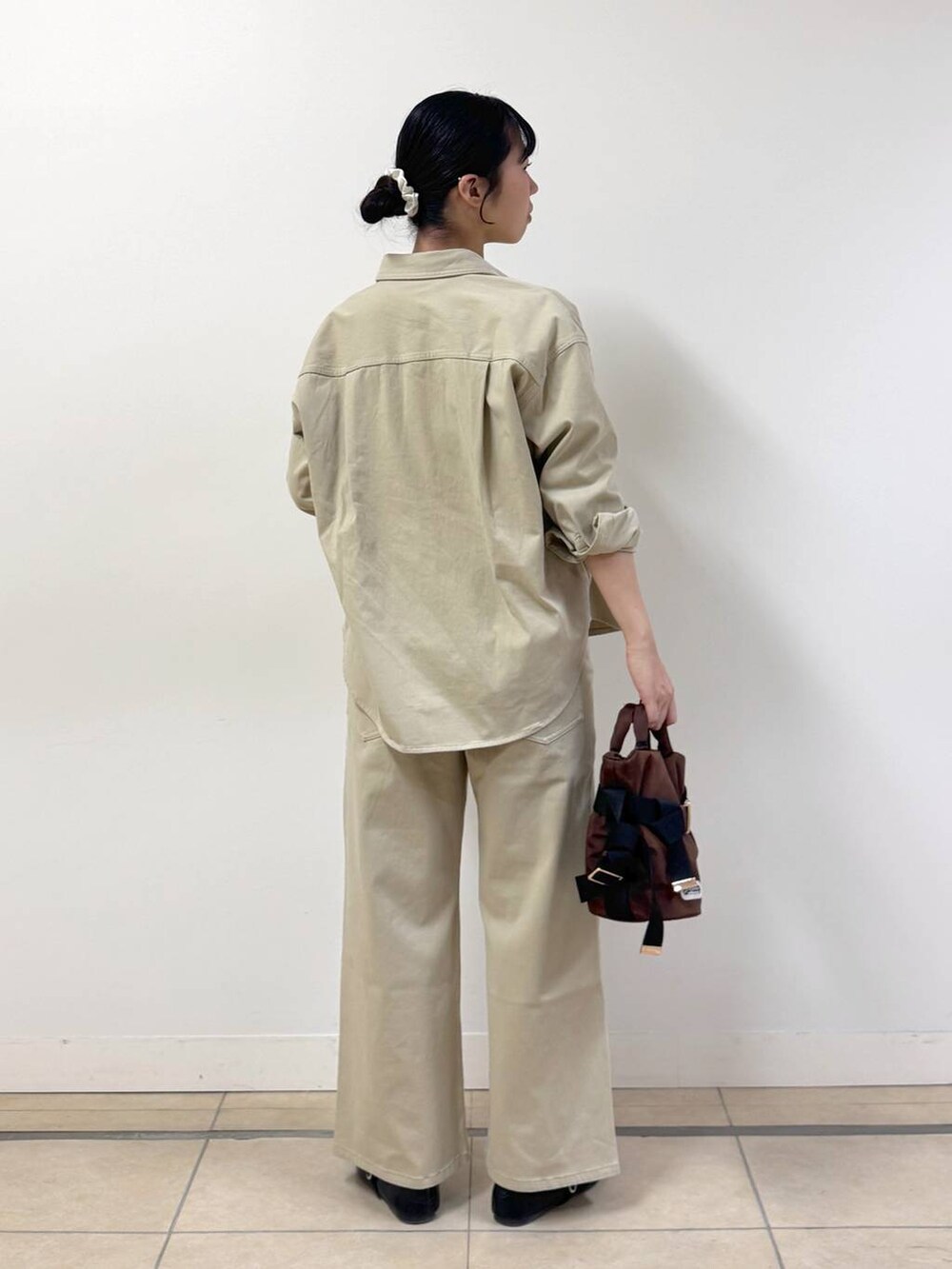 ベージュ系のシャツ/ブラウス、ブラウン系のショルダーバッグ、ベージュ系のデニムパンツを着用したレディースの冬コーディネートの3枚目の写真