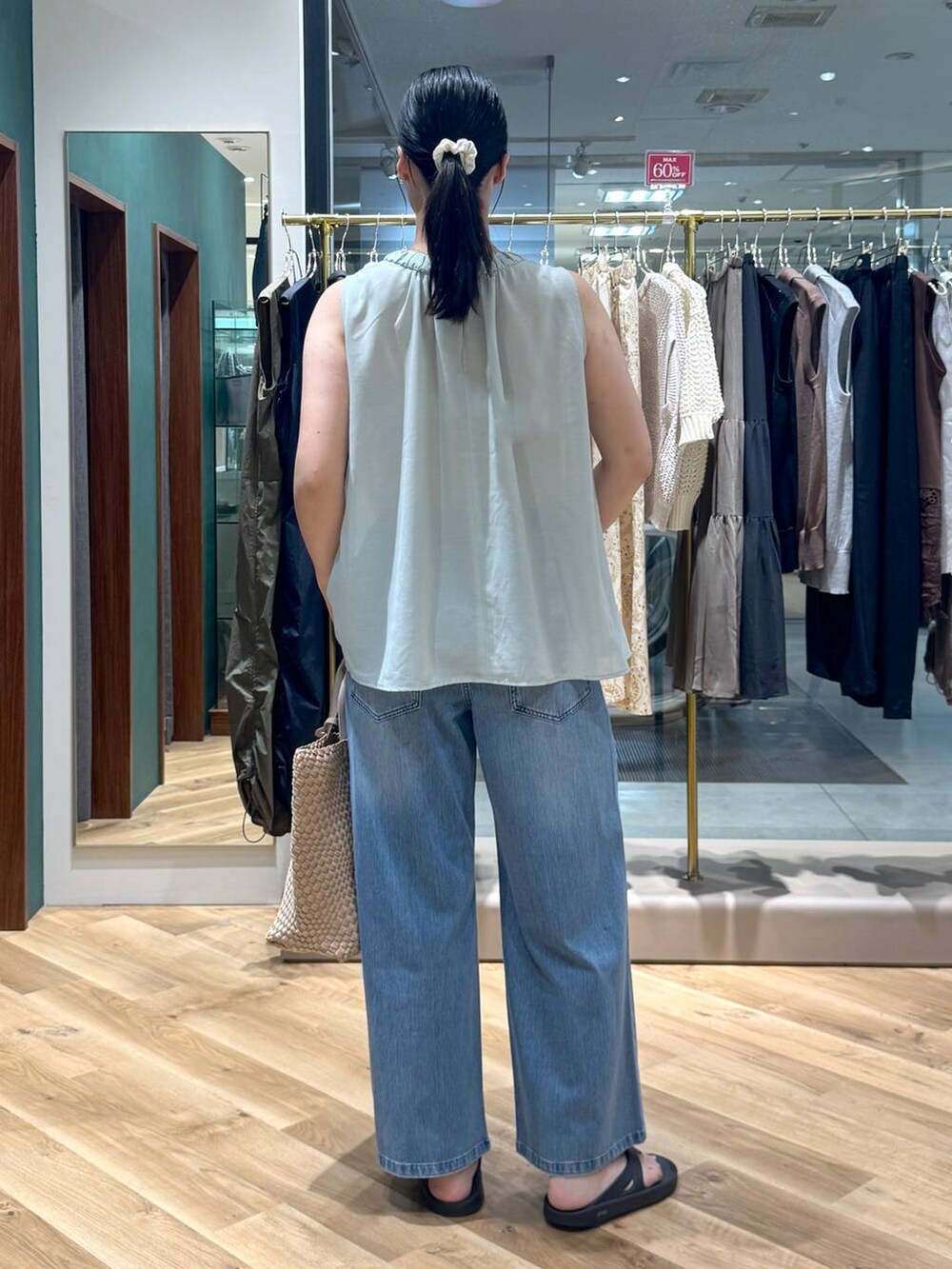 ブルー系のデニムパンツ、ベージュ系のトートバッグ、グリーン系のシャツ/ブラウスを着用したレディースの夏コーディネートの3枚目の写真