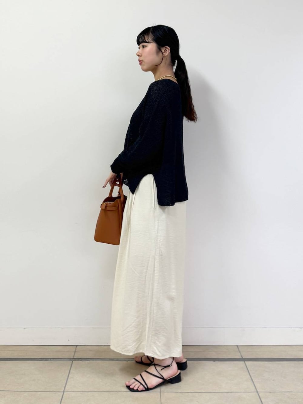 ブラック系のキャミソール、ブラック系のカーディガン/ボレロ、ホワイト系のその他パンツを着用したレディースの春コーディネートの2枚目の写真