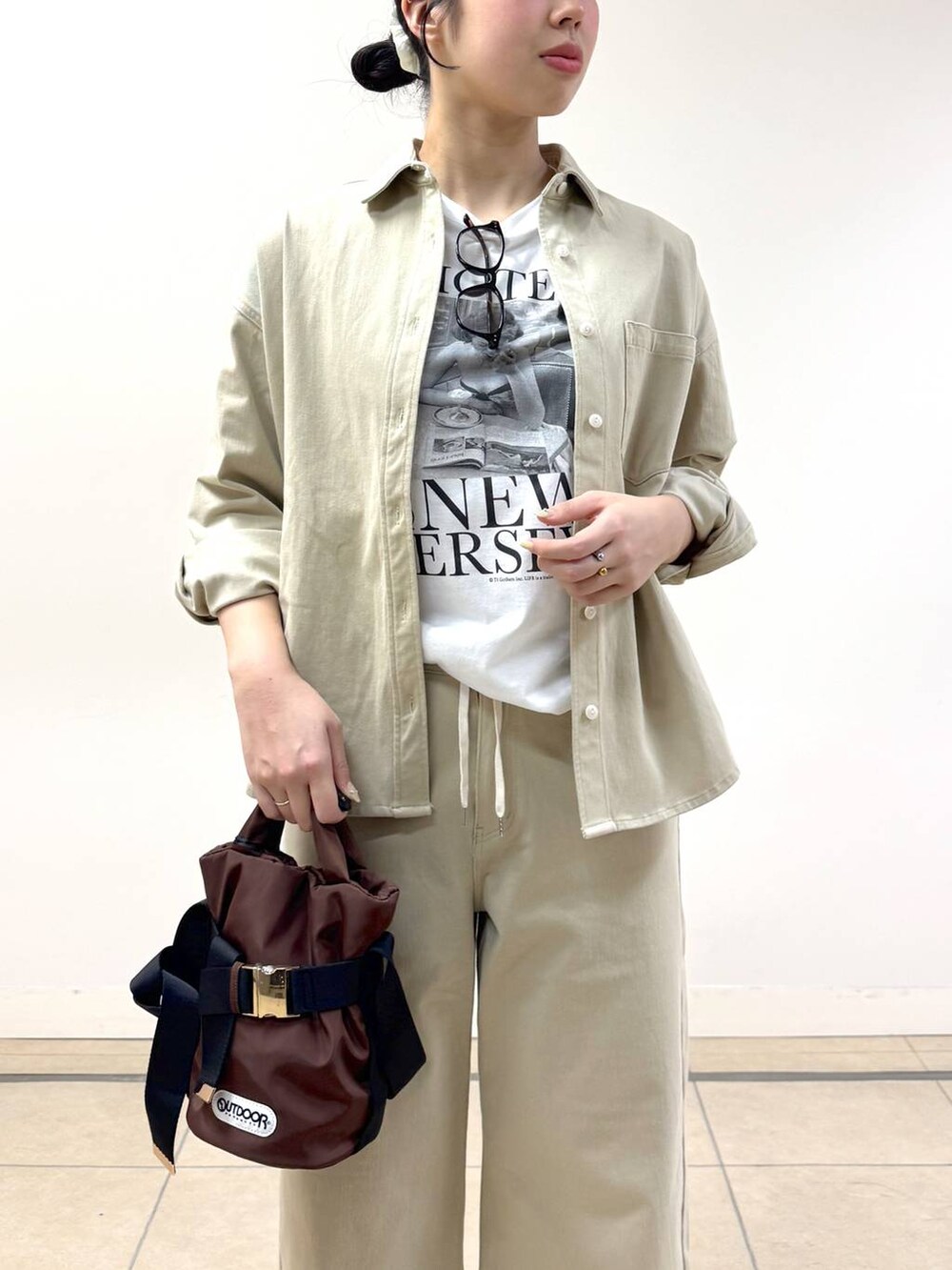 ベージュ系のシャツ/ブラウス、ブラウン系のショルダーバッグ、ベージュ系のデニムパンツを着用したレディースの冬コーディネートの5枚目の写真