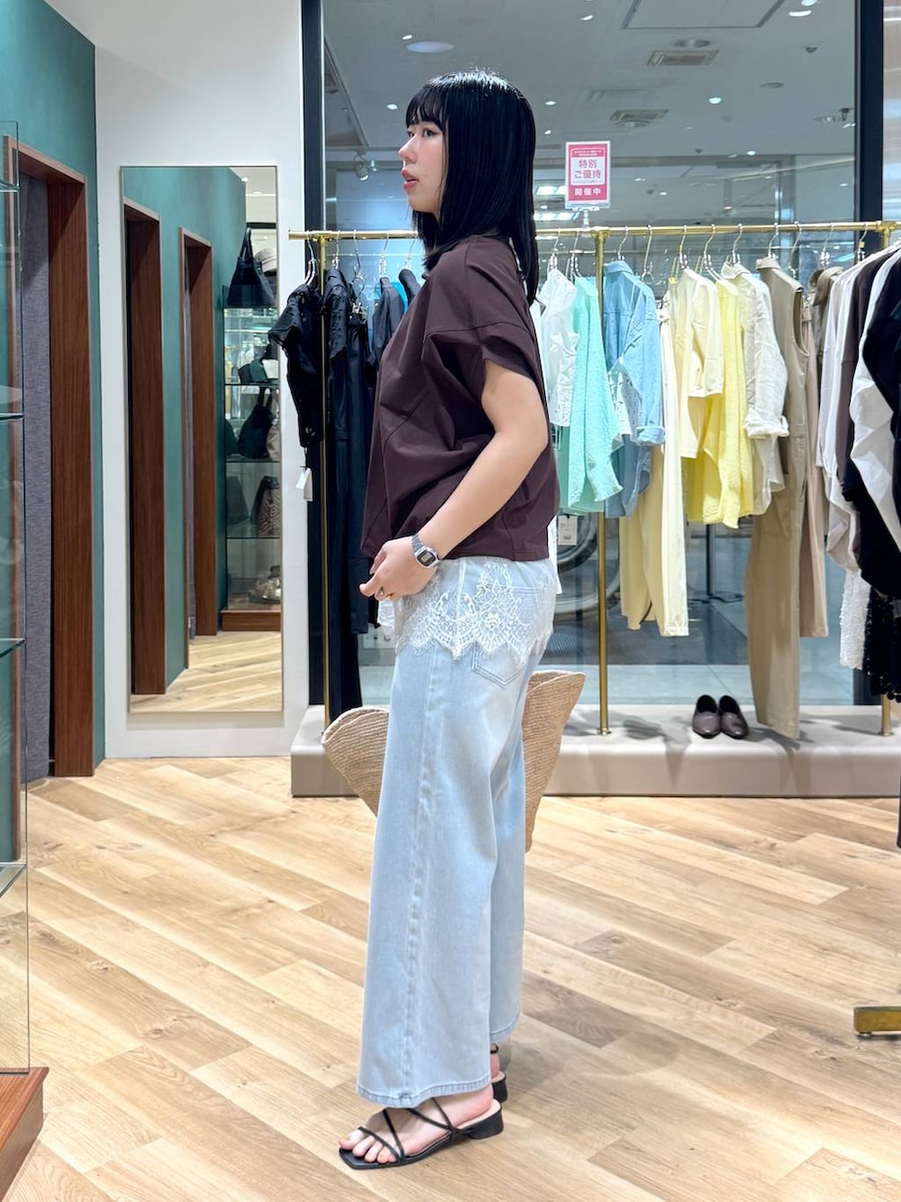 ブルー系のデニムパンツ、ブラウン系のTシャツ/カットソー、ホワイト系のキャミソールを着用したレディースの春コーディネートの2枚目の写真
