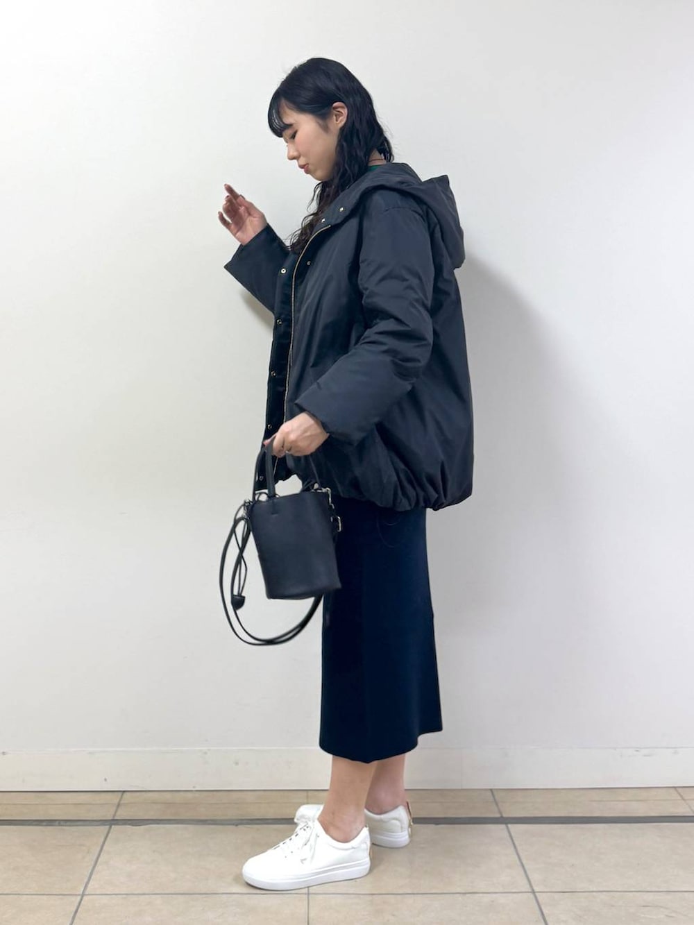 ブラック系のダウンジャケット/コート、ブルー系のニット/セーター、ブルー系のスカートを着用したレディースの冬コーディネートの2枚目の写真