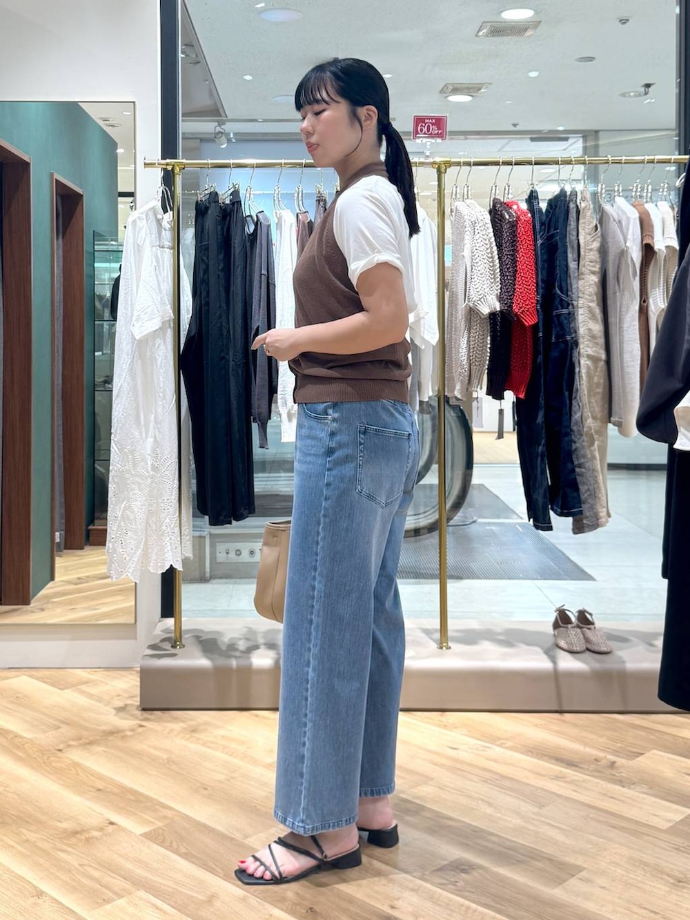 ホワイト系のTシャツ/カットソー、イエロー系のトートバッグ、ブラウン系のベストを着用したレディースの夏コーディネートの2枚目の写真