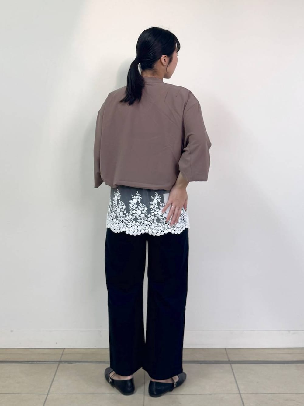 ブラック系のデニムパンツ、イエロー系のブルゾン、ブラック系のショルダーバッグを着用したレディースの春コーディネートの3枚目の写真
