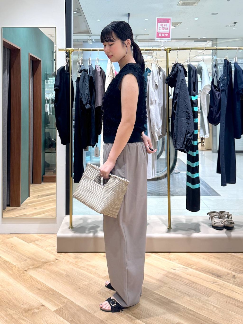 ブラウン系のその他パンツ、ブラック系のニット/セーター、ブラック系のサンダルを着用したレディースの春コーディネートの2枚目の写真