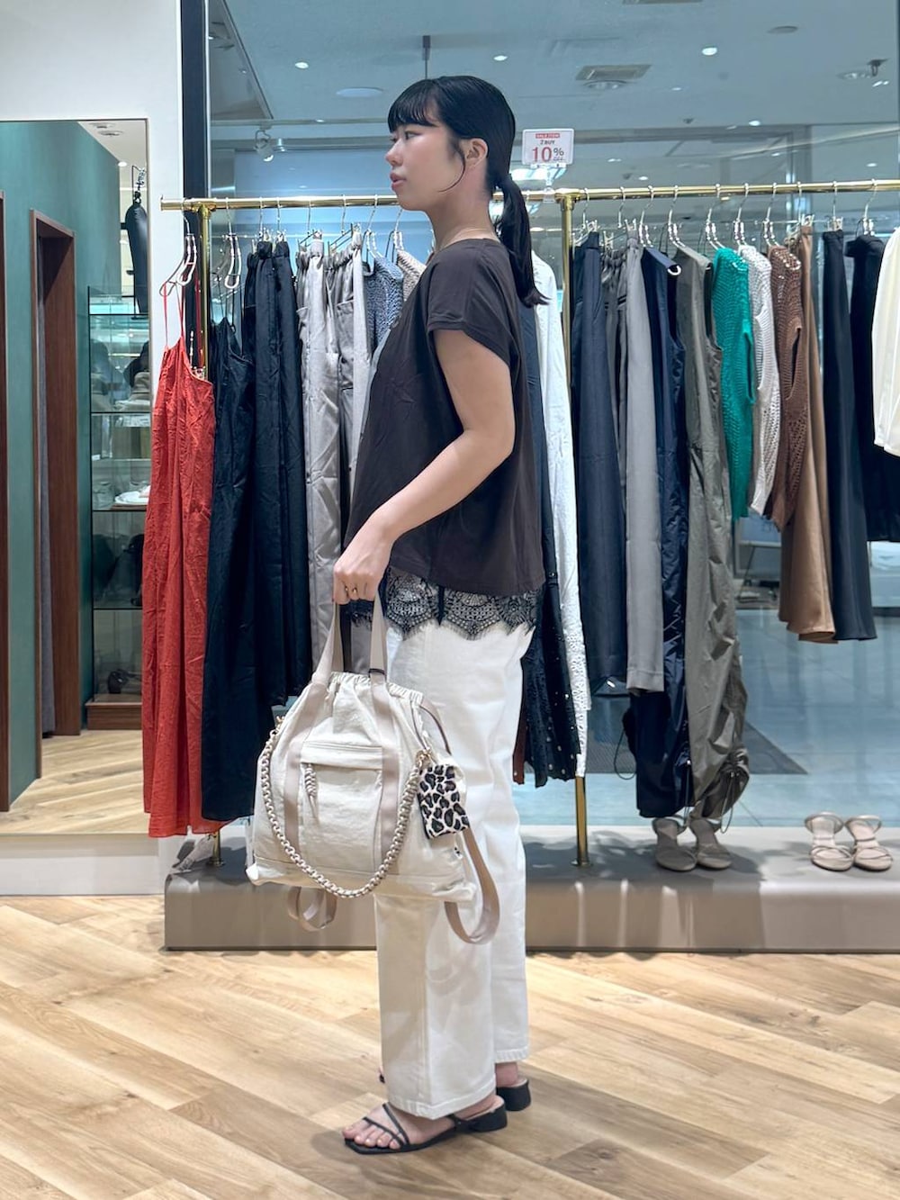 ブラウン系のTシャツ/カットソー、ホワイト系のデニムパンツ、ベージュ系のバックパック/リュックを着用したレディースの夏コーディネートの2枚目の写真