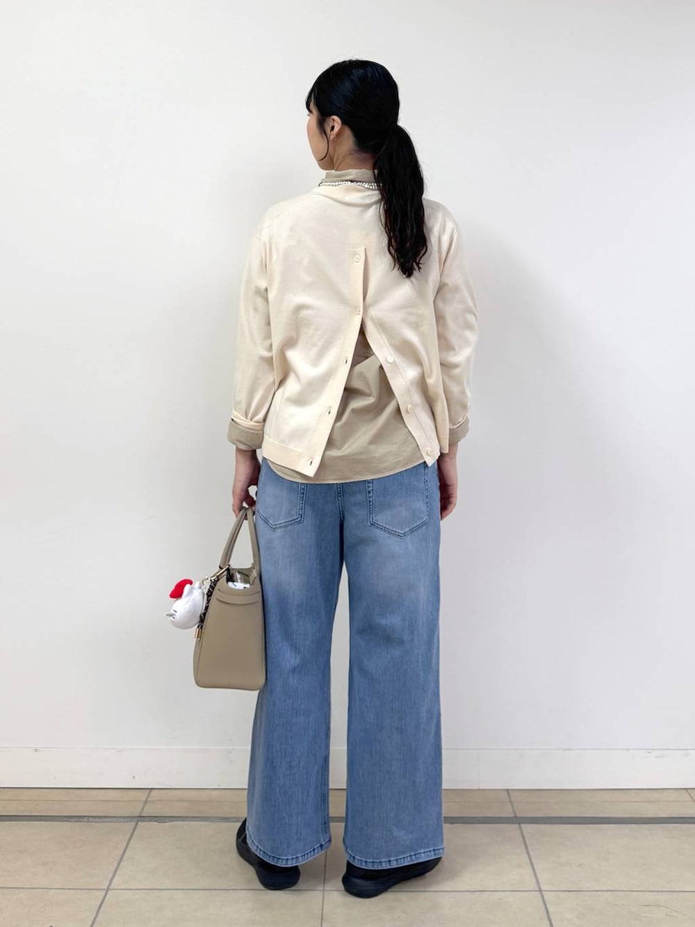 ブルー系のデニムパンツ、ベージュ系のシャツ/ブラウス、ホワイト系のニット/セーターを着用したレディースの冬コーディネートの3枚目の写真