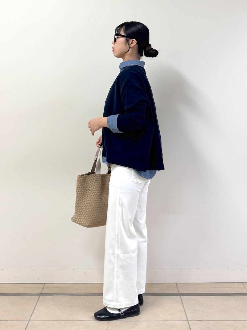 ブルー系のニット/セーター、ベージュ系のトートバッグ、ホワイト系のカーゴパンツを着用したレディースの冬コーディネートの2枚目の写真