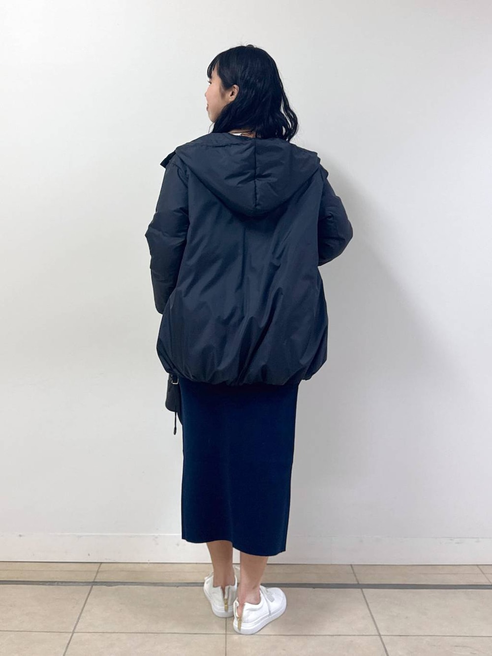 ブラック系のダウンジャケット/コート、ブルー系のニット/セーター、ブルー系のスカートを着用したレディースの冬コーディネートの3枚目の写真